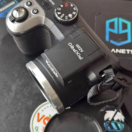 Digital camera with lens, side control dial, and attached strap