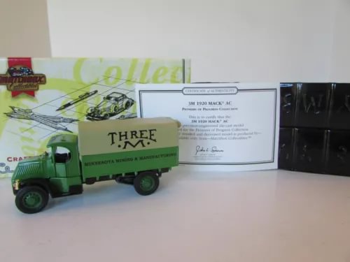 Green diecast Mack truck model with box-style display card and protective tray