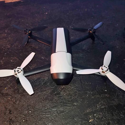 Four-propeller drone with white body and dark bottom