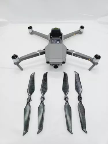 Folded camera drone with four propellers and gray body, front gimbal visible