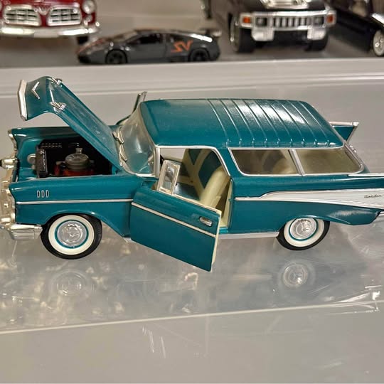 Teal diecast vintage pickup truck model with open driver door