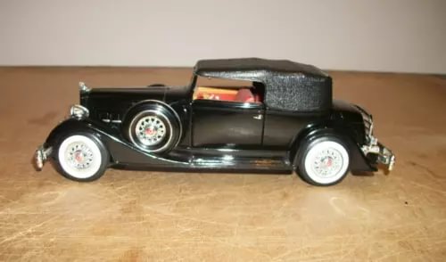 Black open-top 1934 diecast car model with whitewall tires, side view
