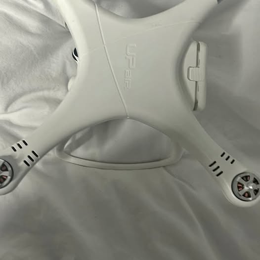 White quadcopter drone with propeller guards and vented motors