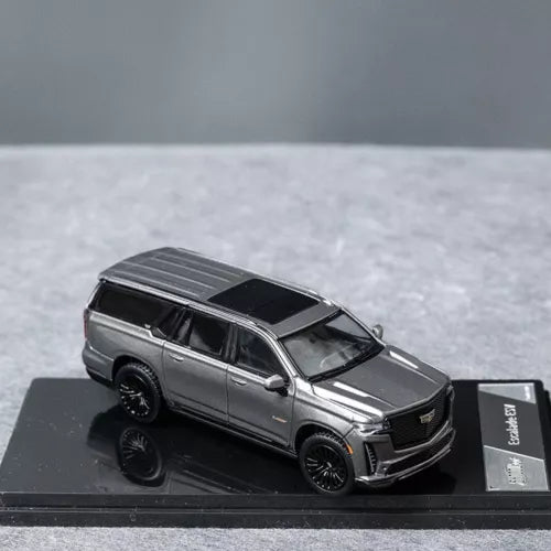 Grey 1/64 diecast SUV model car with black wheels and grille, side view