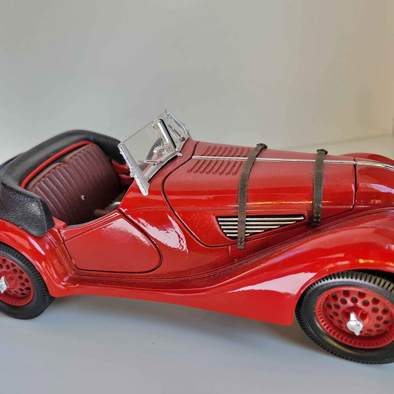 Red diecast convertible sports car with black interior and chrome detailing