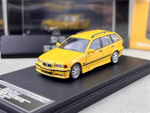Yellow 1/64 scale BMW M3 E36 touring diecast car model, front three-quarter view.
