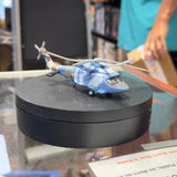 Light blue diecast toy airplane on black circular display stand
