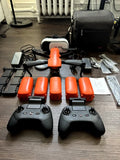 Orange 6K video drone bundle with two controllers, batteries, and charging accessories