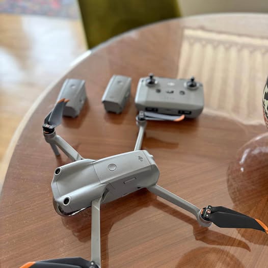 Grey folding drone with four propellers, front-left view, compact body