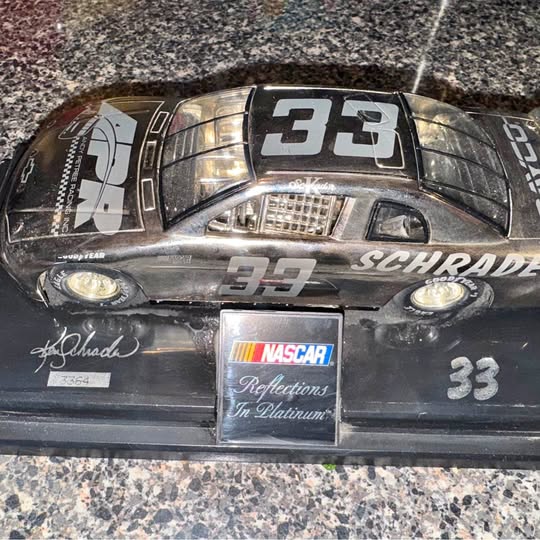Black diecast race car, hood #33 and front NASCAR plate “Reflections in Platinum”