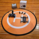 Beginner drone with black controller and orange circular landing pad