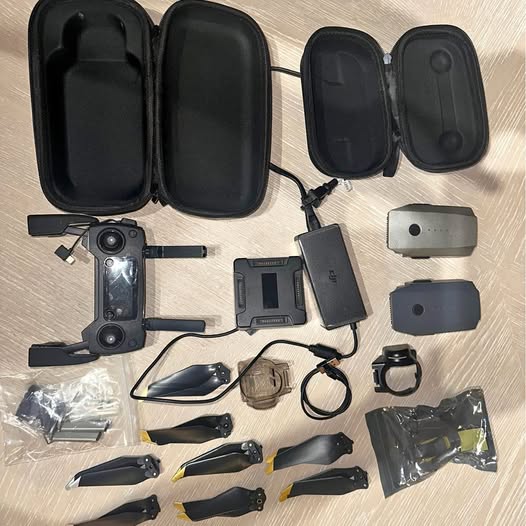 Black drone parts set with controller, camera module, batteries and landing legs