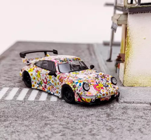 Diecast racing car toy in multicolor floral graphic wrap, black wheels, front 3/4 view.