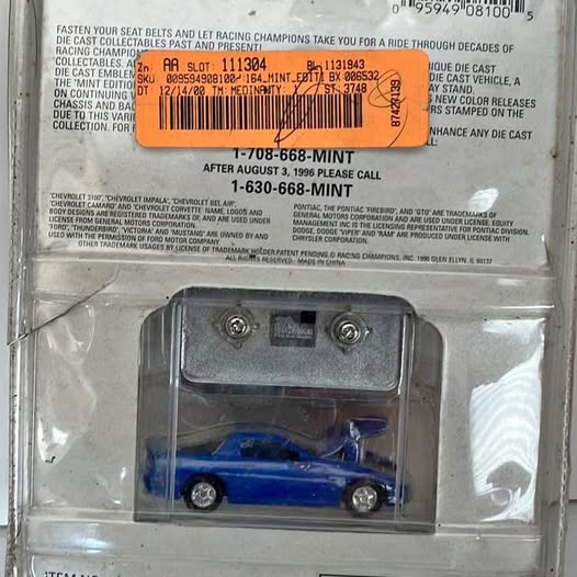 Vintage diecast racing car model in blister pack, blue with black wheels
