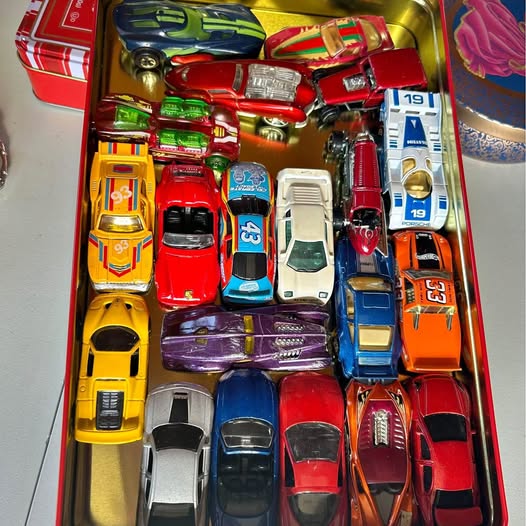 Collectible diecast car set in gold box with assorted red, blue, yellow, and purple cars