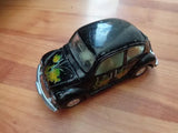 Black fish-decal Volkswagen-style Beetle diecast model car, front 3/4 view