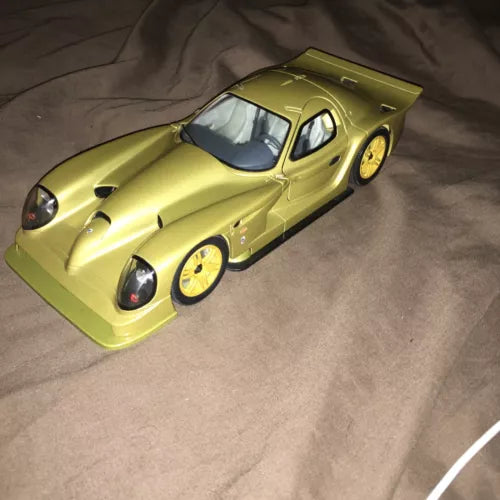 Gold diecast model car, front three-quarter view with black windshield and hood