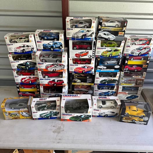Set of 1/24 diecast car models in boxed packaging, assorted racing cars
