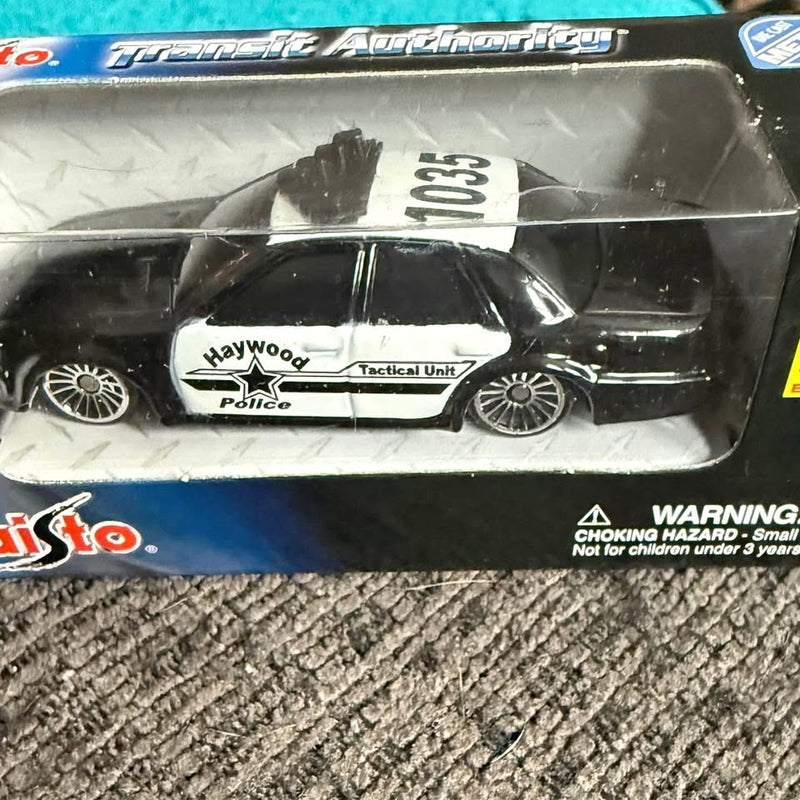 Diecast police tactical unit toy car in black and white with graphics, boxed