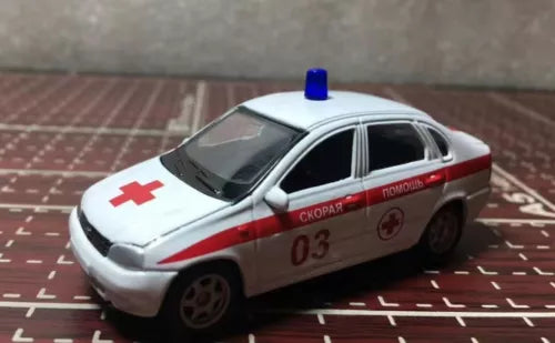 Diecast emergency car model, white with red markings and blue roof light