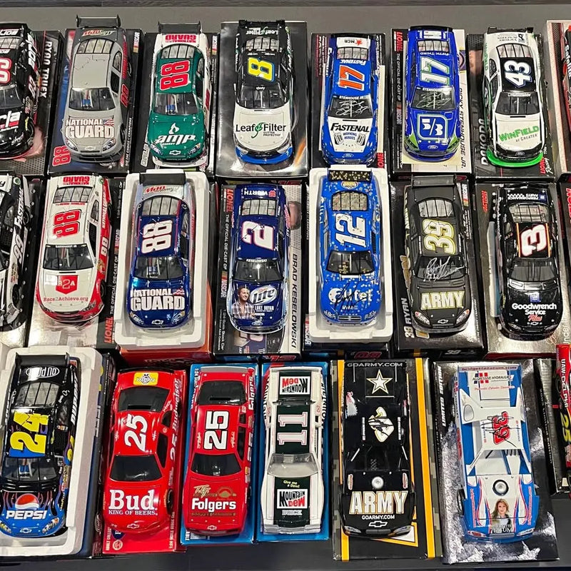 Assorted NASCAR diecast race cars in plastic display boxes, multiple designs visible