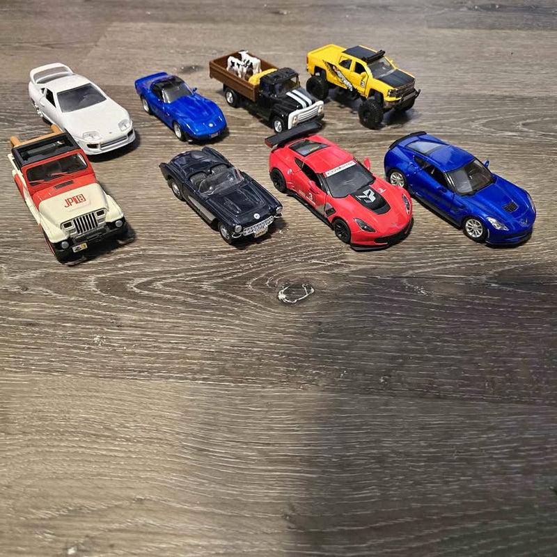 Diecast car set with multiple vehicles in white, blue, red, yellow, and black