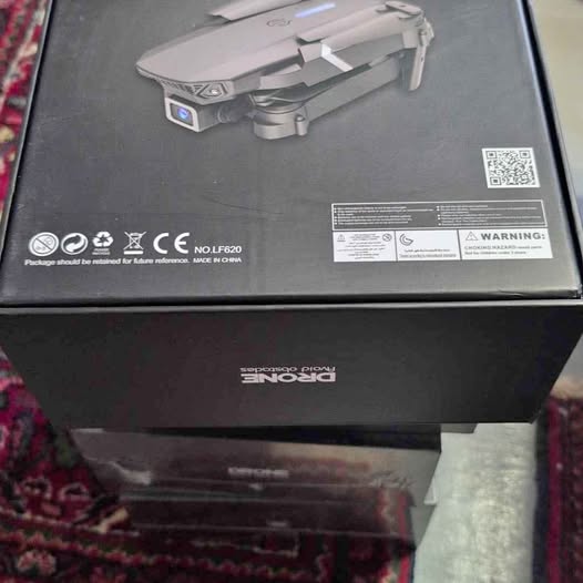 Boxed quadcopter drone with foldable arms and front LED
