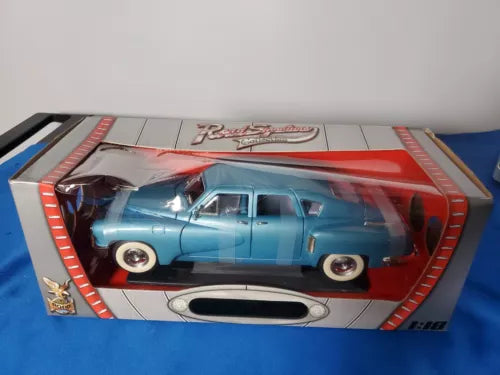 Light blue die-cast car model in display box with red trim and clear window