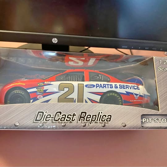 Die-cast replica race car model in box, #21 blue and red with sponsor decals