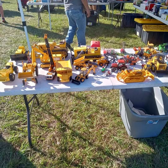 Assorted yellow and red diecast construction vehicles on a display table