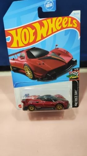 Red diecast race car with rear spoiler, in retail blister pack