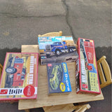 Diecast vehicle toys in boxes with trucks, mounted on a wooden display stand
