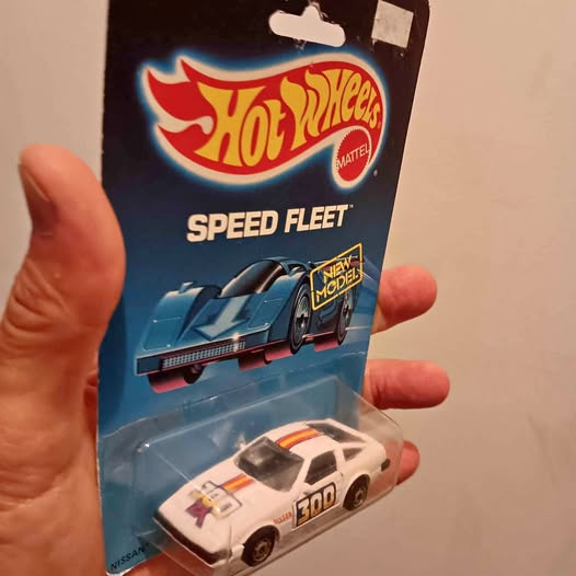 Hot Wheels diecast Nissan 300 1988 car, white with orange accents on card