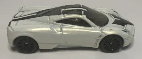 Diecast toy car, pearl white Pagani Huayra with black wheels, side view