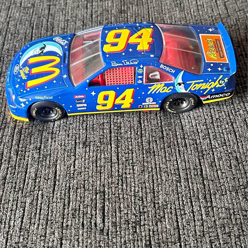 Blue diecast race car with #94 graphic and sponsor decals, front side view.
