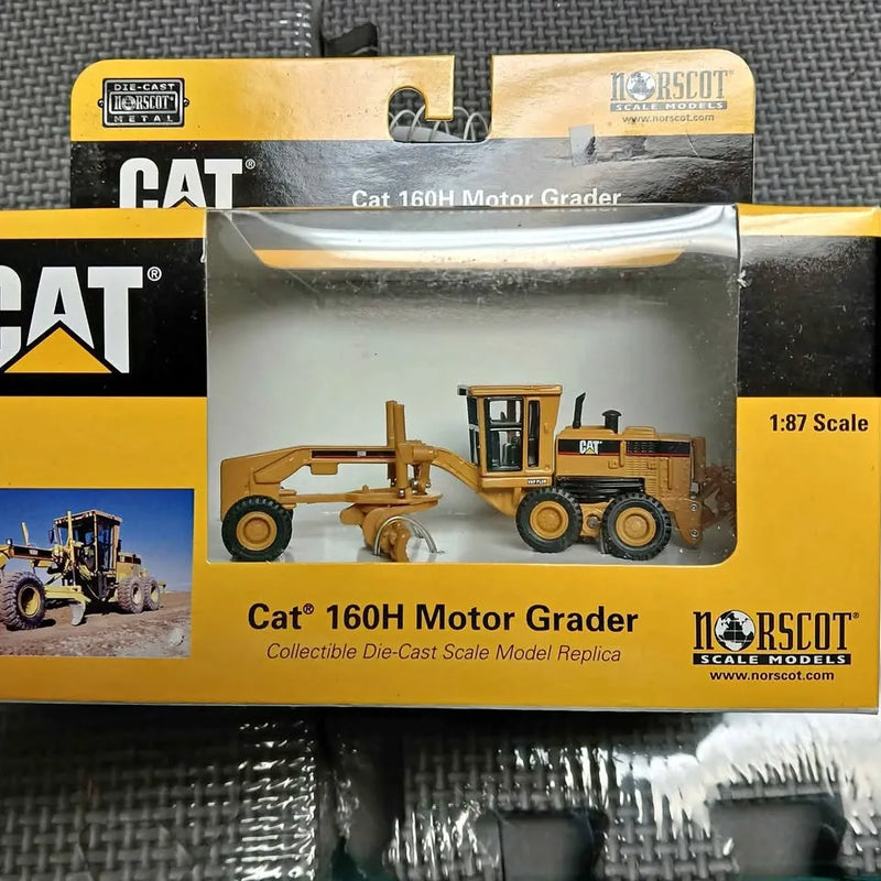 Boxed Cat 160H motor grader diecast model, 1:87 scale, yellow and black.