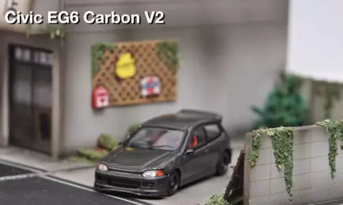 Diecast sports car toy, dark gray hatchback with front grille and headlights visible