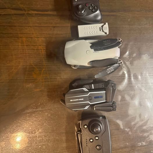 Quadcopter drone with camera and prop guards, shown with controller device
