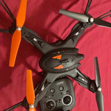 Black drone with orange propellers and visible controller ports