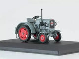 Diecast tractor model with gray body, red wheels, and front grille details, side view