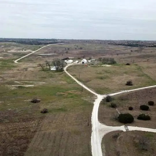 Drone with white dome near crossroads in rural field