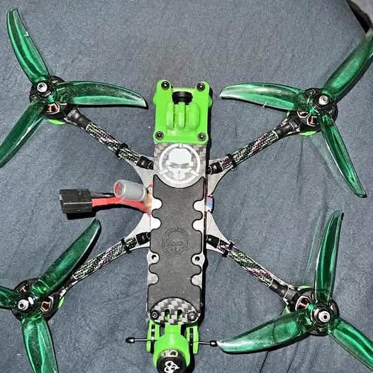 FPV drone with green propellers and black frame, top view