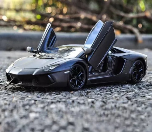 Diecast sports car model in dark blue/gray with open scissor doors and black wheels.