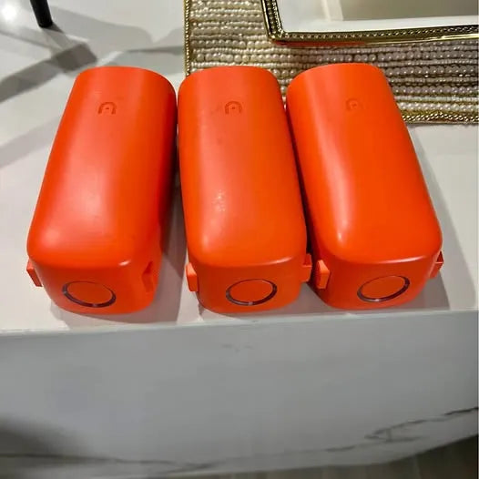 Set of three orange cylindrical devices with circular ports