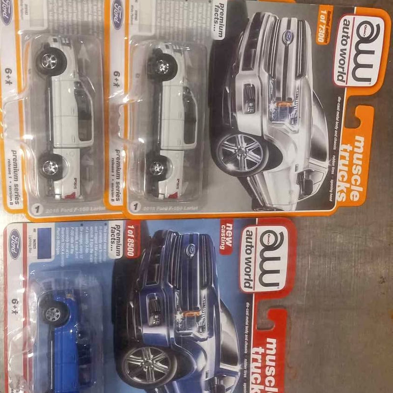 Diecast Ford trucks in blister packs, silver and dark blue pickups with wheels visible