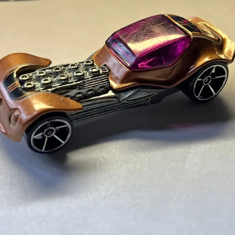 Diecast toy car with bronze body, purple windshield, exposed engine detail, black wheels