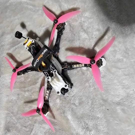 FPV racing drone with four pink propellers and black frame, bind-and-fly