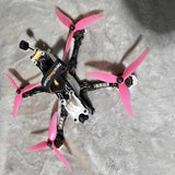 FPV racing drone with four pink propellers and black frame, bind-and-fly