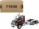 Black day cab tractor diecast model with chrome grille and front bumper, front three-quarter view