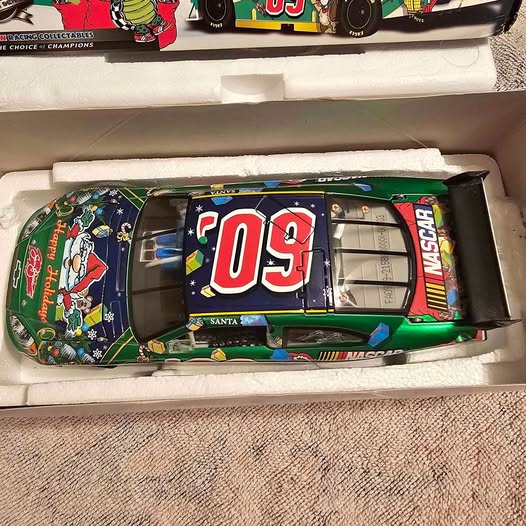Green diecast race car with Santa and '03' decal, wrapped in gift-style graphics.